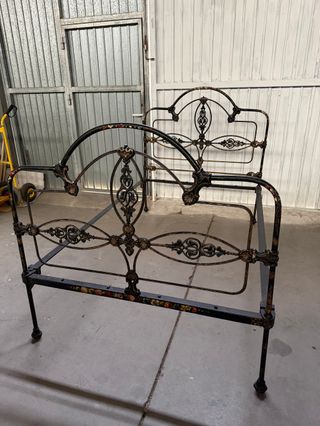 Cama de forja antigua con detalles florales