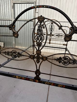 Cama de forja antigua con detalles florales