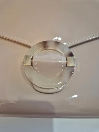 Bolso de mano beige con adorno metálico