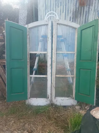 Antigua ventana doble con contraventanas verdes