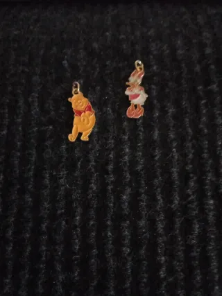 Colgantes de personajes dorados y rojos.Metal