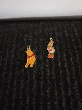 Colgantes de personajes dorados y rojos.Metal