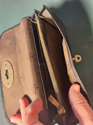 Cartera Mulberry de piel negra con cierre dorado.