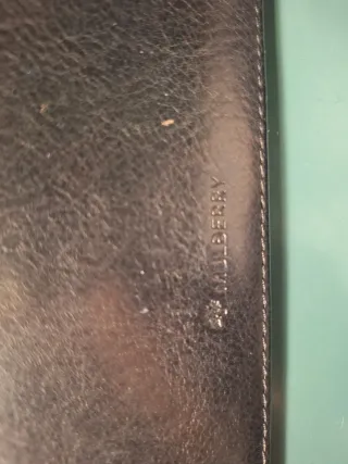 Cartera Mulberry de piel negra con cierre dorado.