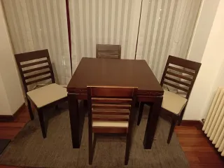 Mesa extensible comedor con cuatro sillas a juego.