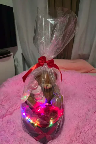 Oso de peluche con rosas y luces