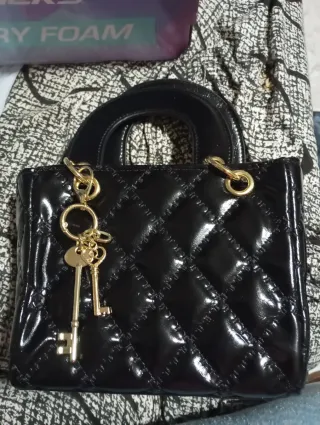 Bolso de mano negro acolchado con llavero