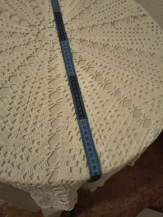 Mesa redonda con mantel tejido, crochet y debajo ,