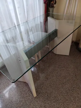 Mesa de comedor tapa de cristal y pies de madera.