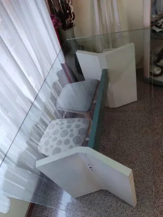 Mesa de comedor tapa de cristal y pies de madera.