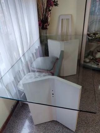 Mesa de comedor tapa de cristal y pies de madera.