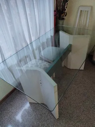 Mesa de comedor tapa de cristal y pies de madera.