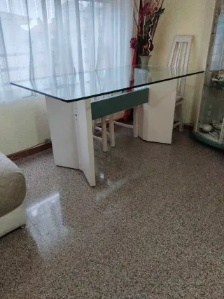 Mesa de comedor tapa de cristal y pies de madera.