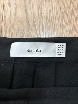 Falda plisada negra con cadena