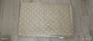 Colcha beige y blanca con lunares