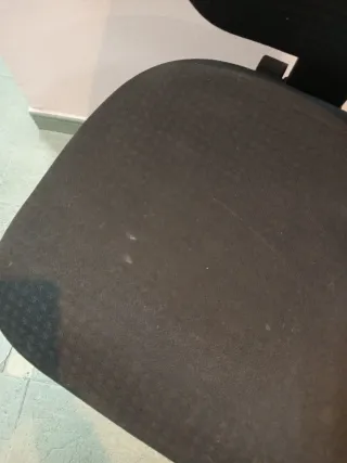 Silla de oficina negra sin brazos poco usada.