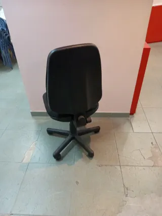 Silla de oficina negra sin brazos poco usada.