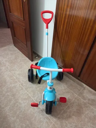 Triciclo infantil azul con barra de paseo