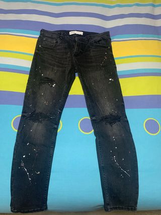 Pantalones vaqueros negros rotos y manchados