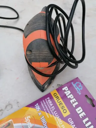 Lijadora eléctrica naranja con papel de lija