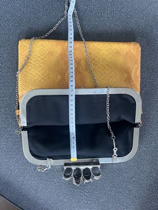 Bolso de mano con calaveras y joya.