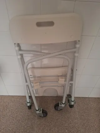 Silla geriátrica para baño con ruedas plegable.