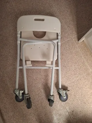Silla geriátrica para baño con ruedas plegable.