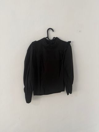 Blusa negra con volantes y mangas abullonadas