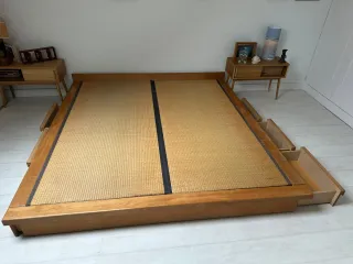 Cama estilo japonés con tatami y cajones.