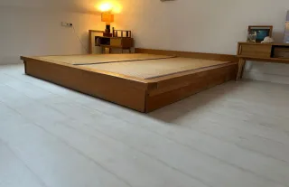 Cama estilo japonés con tatami y cajones.