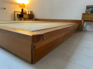 Cama estilo japonés con tatami y cajones.