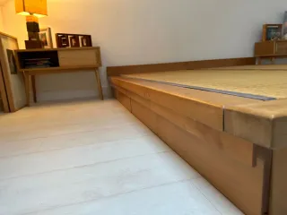 Cama estilo japonés con tatami y cajones.