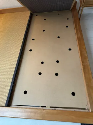 Cama estilo japonés con tatami y cajones.