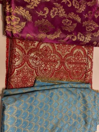 Telas de fallera con bordado dorado.