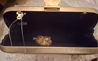 Bolso de mano dorado con hoja