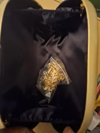 Bolso de mano dorado con caja