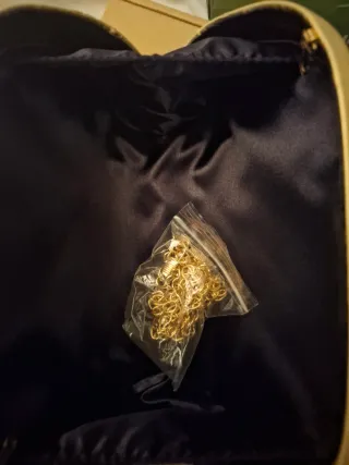 Bolso de mano dorado con caja