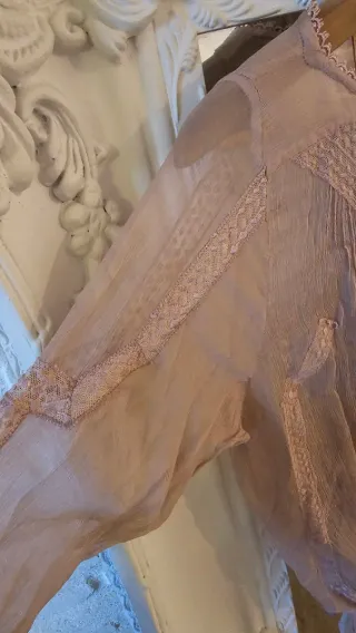 Camisa de encaje rosa palo o color nude.