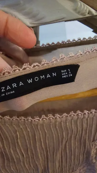 Camisa de encaje rosa palo o color nude.