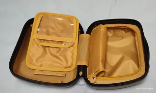 Cojín gris y beige y neceser de viaje dorado