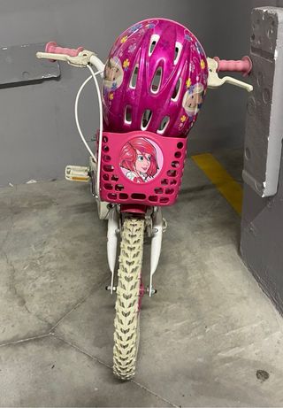 Bicicleta niña con cesta y casco.