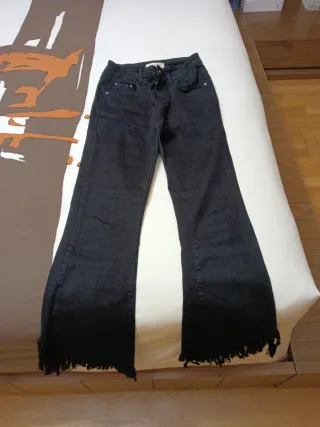 Pantalón negro bajo asimétrico deshilachado