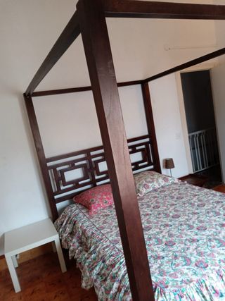 Cama con dosel de madera y tela