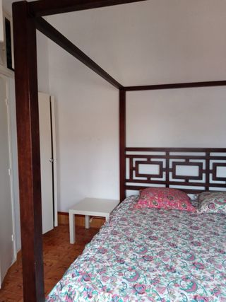 Cama con dosel de madera y tela