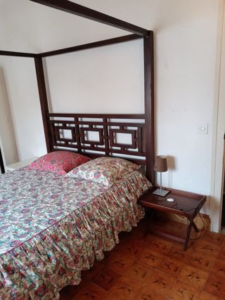 Cama con dosel de madera y tela