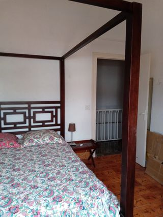 Cama con dosel de madera y tela