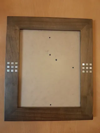 Marco de fotos de madera con detalles metálicos.