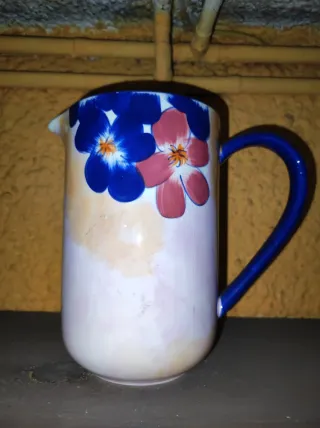 Jarra de cerámica con flores azules y rosas