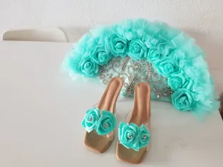 Zapatos dorados y abanico turquesa