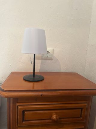 Mesita de noche madera con lámpara.